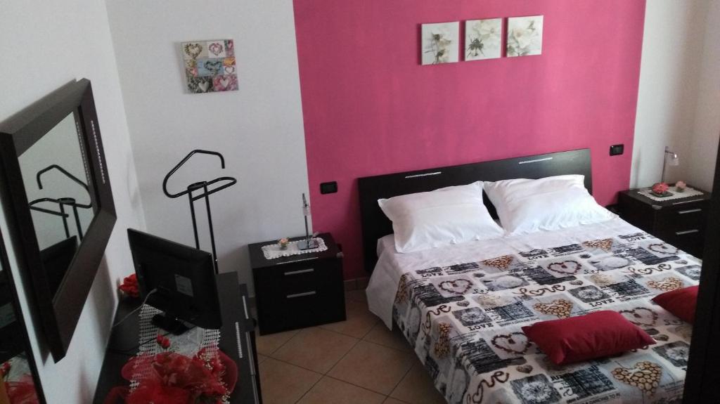サン・サルヴォにあるB&B Belvedereのピンクの壁、ベッド1台付きのベッドルーム1室
