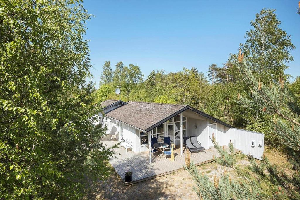 een klein wit huis midden tussen de bomen bij 1502-Aakirkeby-Malurtvej-7 in Vester Sømarken