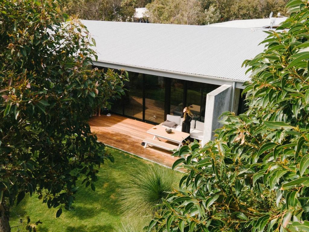Una vista aérea de una casa con una mujer parada en una terraza. en Nativ Escape - A luxurious retreat in Margaret River, en Margaret River Town