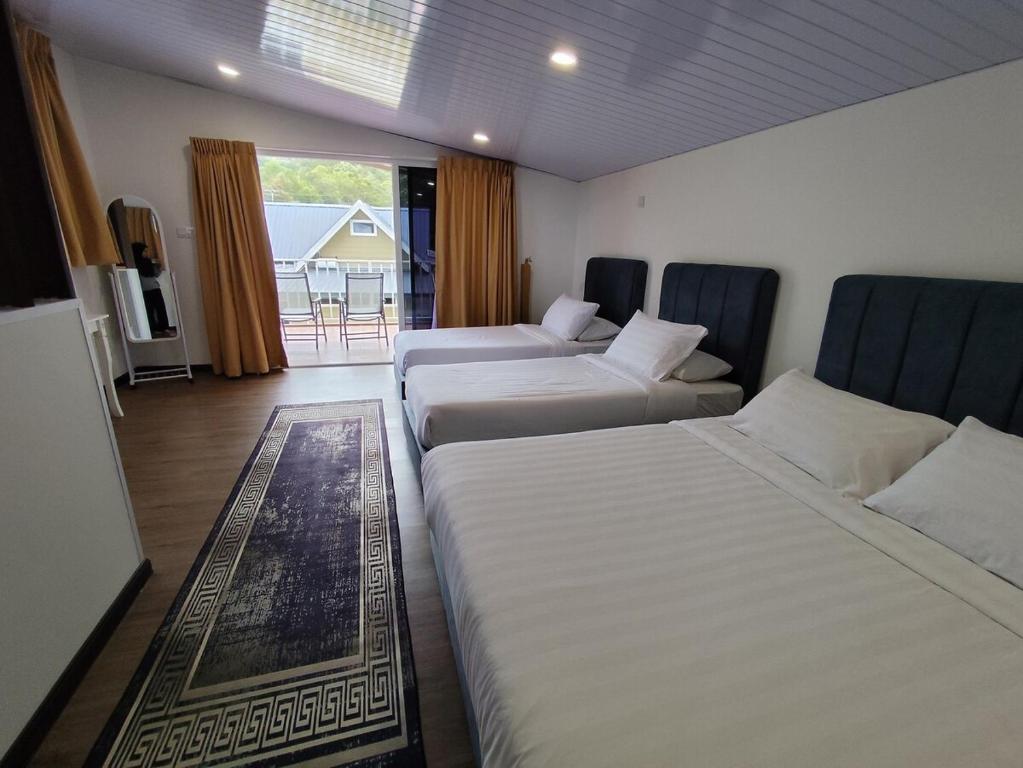 a hotel room with two beds and a balcony at Kundasang Komfy Villa with Mount Kinabalu View in Kundasang