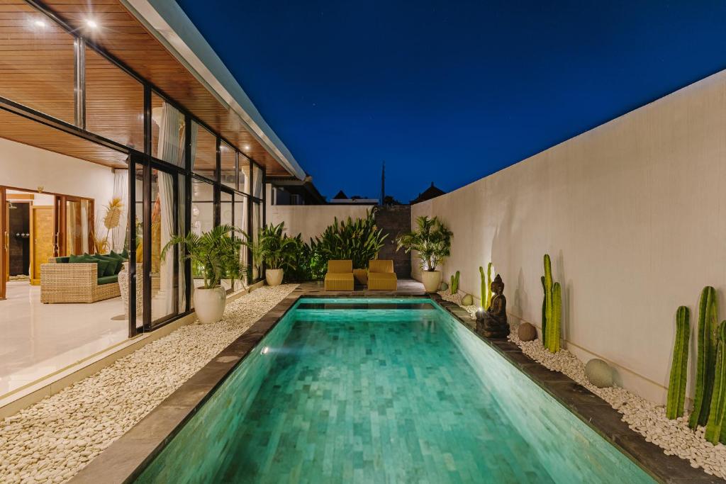 a swimming pool in the middle of a house at Arizona Villa by Betterplace in Cemagi