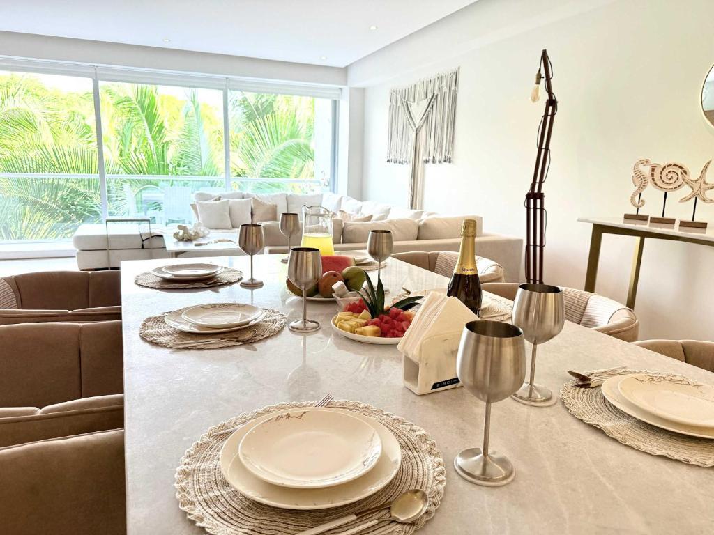 a living room with a table with plates and wine glasses at Bolongo 3BR your exclusive oceanfront escape in Punta Mita