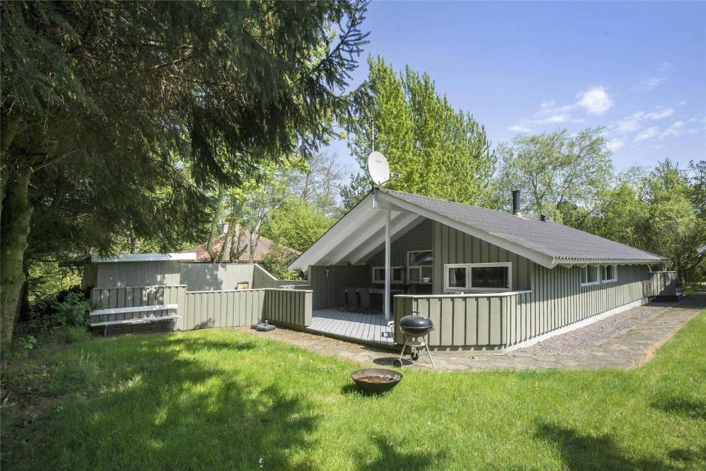 ein grünes Gebäude mit einem großen Hof mit einem Haus in der Unterkunft 1412 Aakirkeby - Boesparken 12 in Vester Sømarken