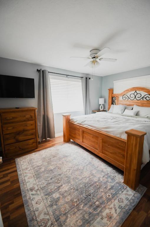 a bedroom with a large wooden bed and a television at Bright and Peaceful Apt in Midvale in Midvale