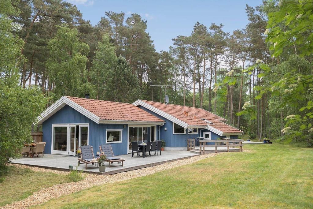 a blue house with a porch and a patio at 2608-Nexo-Munkegardsskoven-17 in Neksø