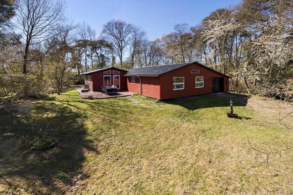 a small red house in the middle of a yard at 3712-Nexo-Aastien-8 in Neksø