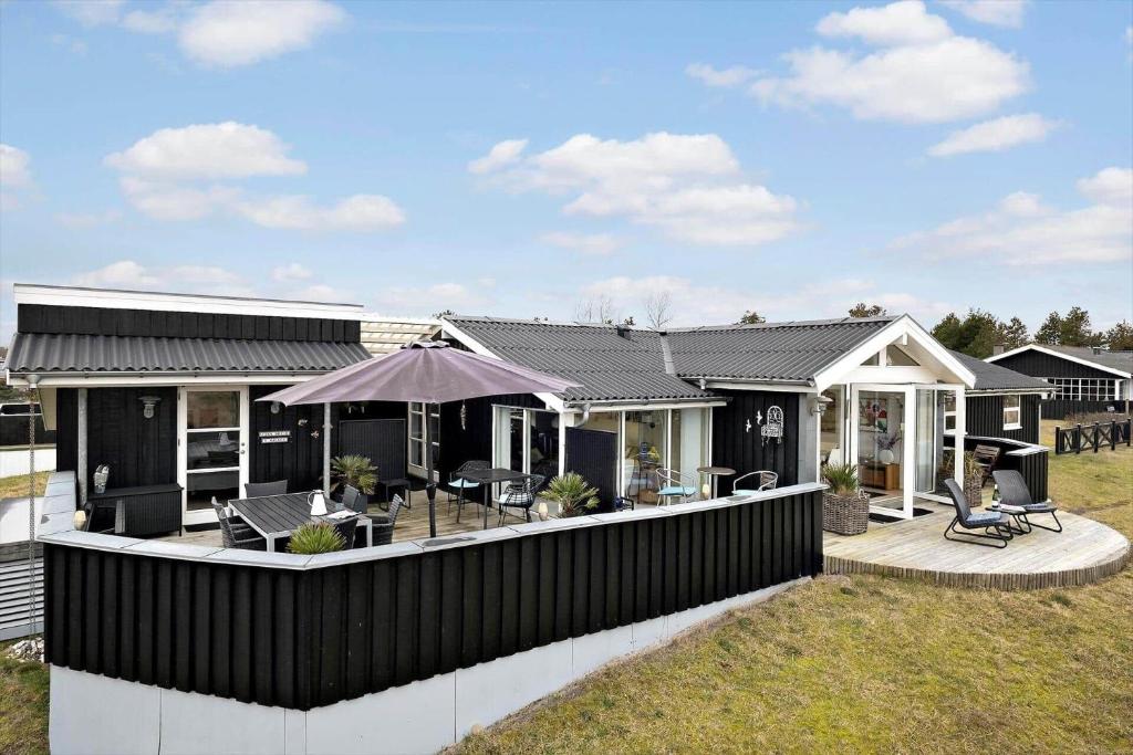 a house with a black roof and a deck at HA344-Saeby-Annesvej-1 in Sæby