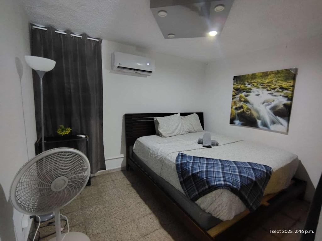 Un dormitorio con una cama y un cuadro en la pared. en Sleep Relax 2, en Fajardo