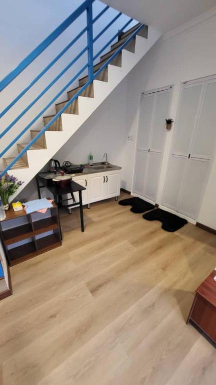 a room with a staircase with a desk and a table at Hillside Suites Kundasang in Ranau