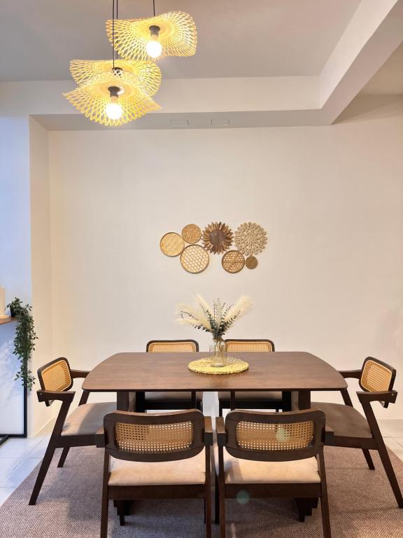 ein Esszimmer mit einem Holztisch und Stühlen in der Unterkunft NAZS Homestay sungai petani in Sungai Petani