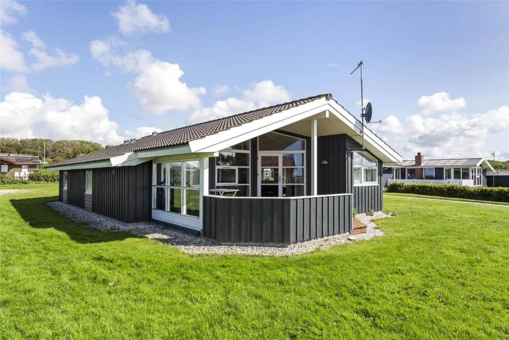 a black and white house with a green lawn at LF550-Vestervig-Ingersvej-20 in Vestervig