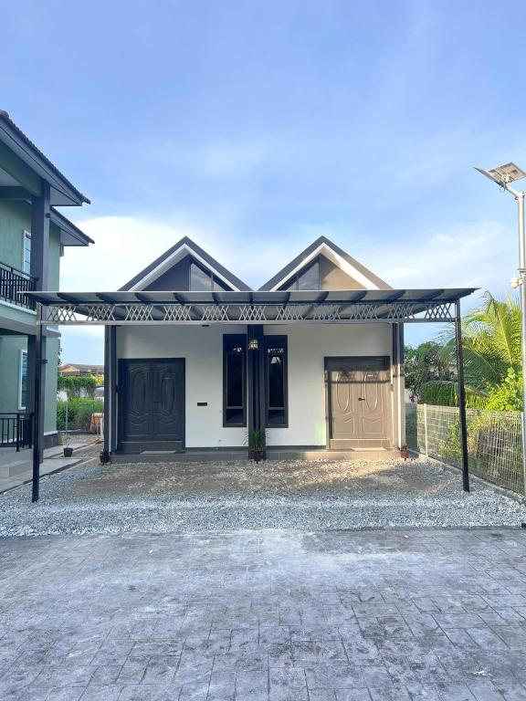 een huis met een grote oprit ervoor bij Ariyanie Roomstay 2 in Kuala Terengganu