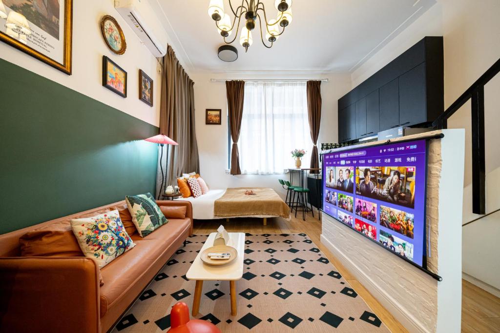 上海市にあるShanghai Hills& Well-time Nanyang Charm BnB close to West Nanjing Rd and line 2 Jing'an Templeのソファと大型テレビのあるリビングルーム