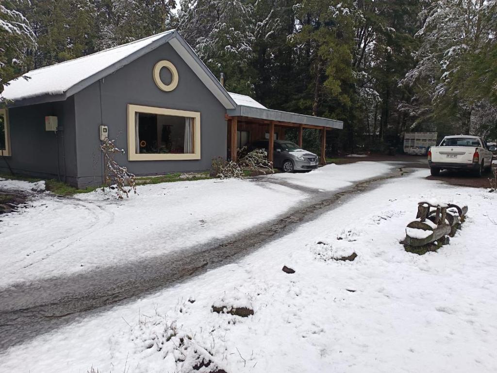 a house with a snow covered driveway in front of it at Cabañas Ladera Sur Melipeuco in Melipeuco