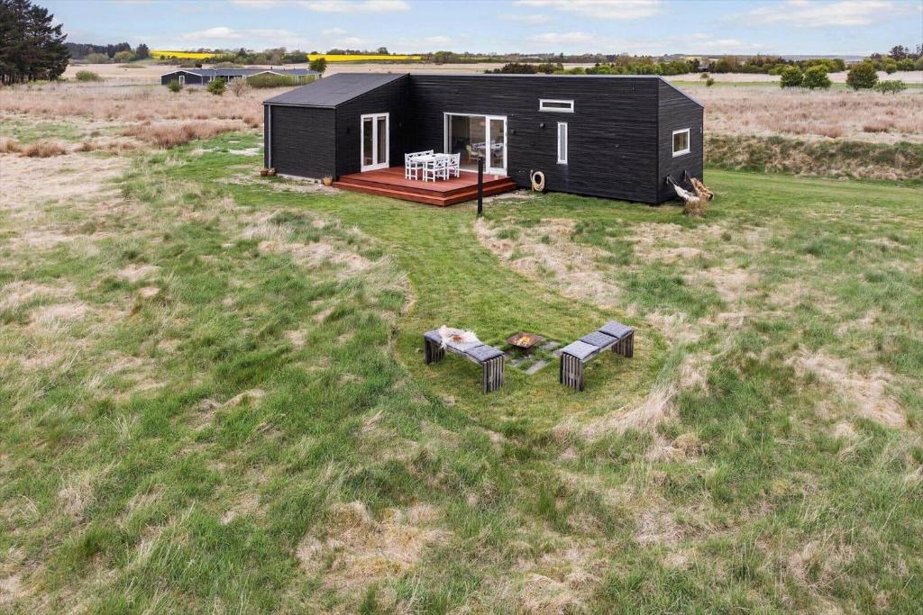 a black tiny house sitting in a field at LF13025-Oster-Assels-Kanalstien-3 in Øster Assels