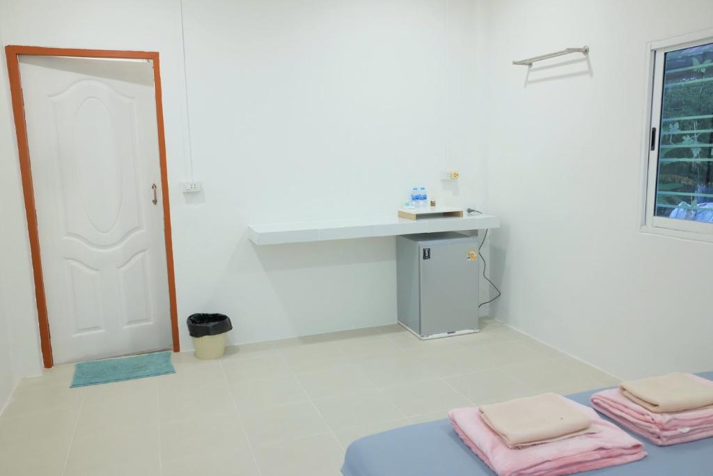 a white room with a table and two folded towels at ศาลาลำดวนรีสอร์ต in Ban Sala Lamduan