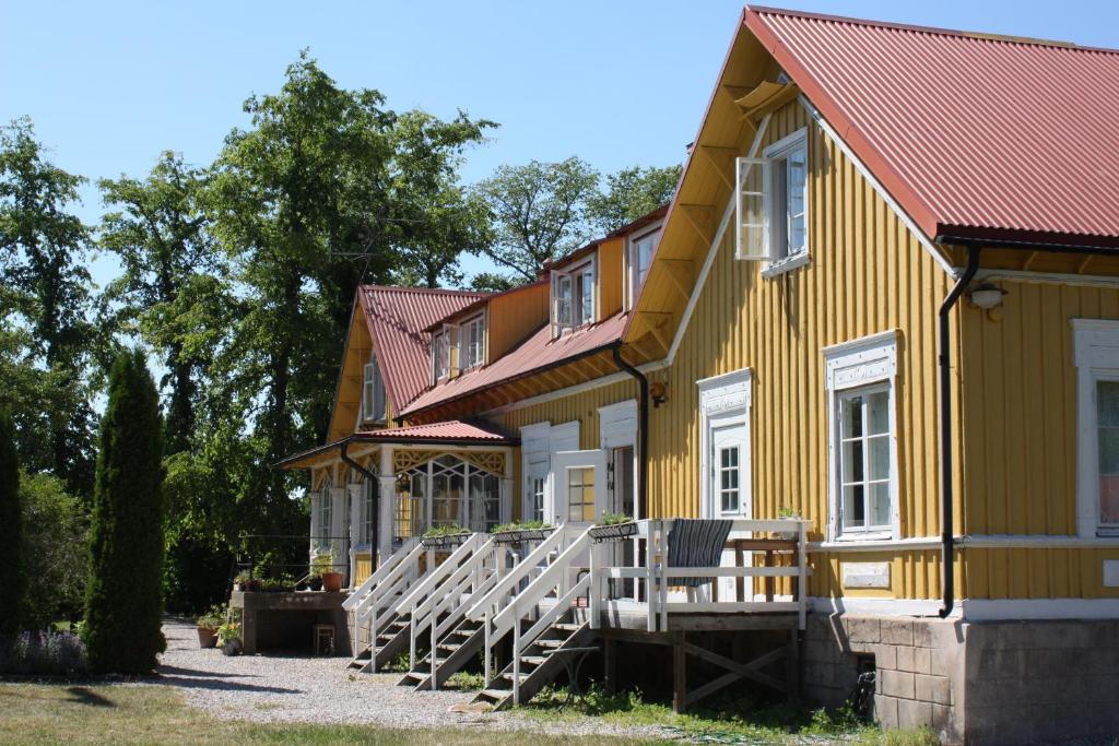 een geel huis met een rij stoelen ervoor bij Gula Hönan Guest House in Ronehamn