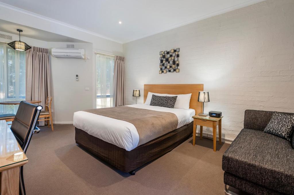 a hotel room with a bed and a couch at Comfort Inn Coach & Bushmans in Seymour