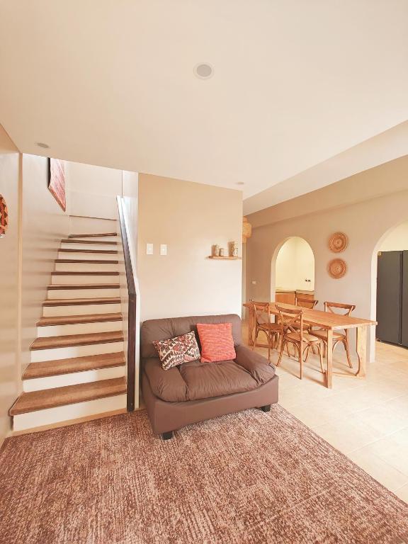 a living room with a couch and a staircase at The Ubuntu House in Dauis