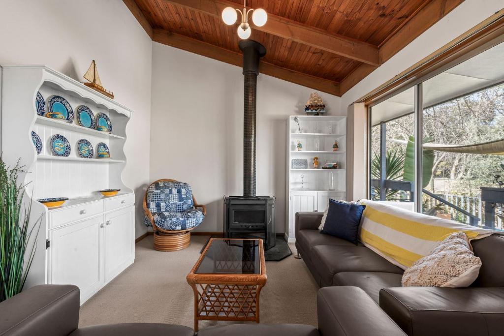 a living room with a couch and a stove at Harvey Rd Beach House in Saint Leonards
