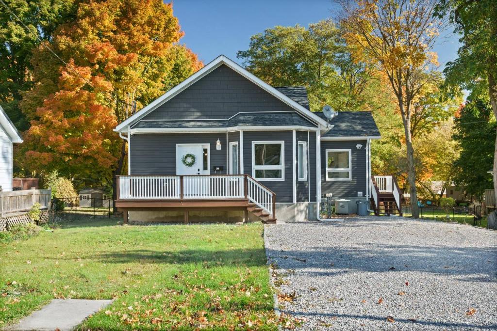 une petite maison avec un porche et une allée dans l'établissement Spacious 4Bdrm Home | Patio, BBQ, Walk to Lake, à Fenelon Falls