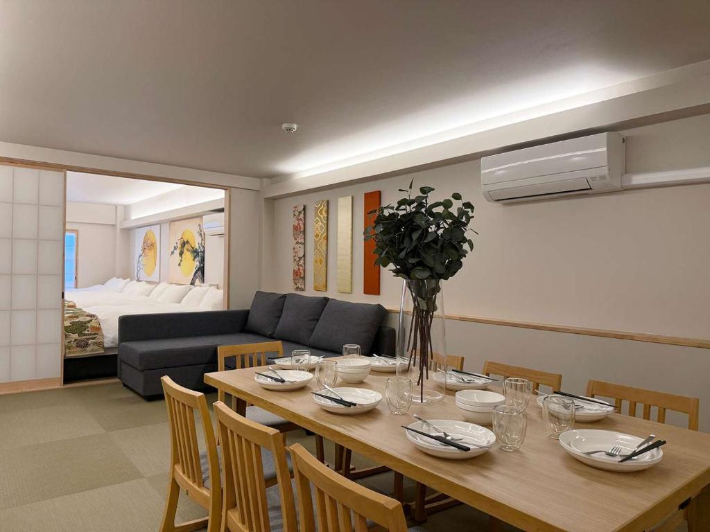 a dining room with a table and a couch at b hotel Miyajima Omotesando - Sacred Island Stay 21 in Miyajima