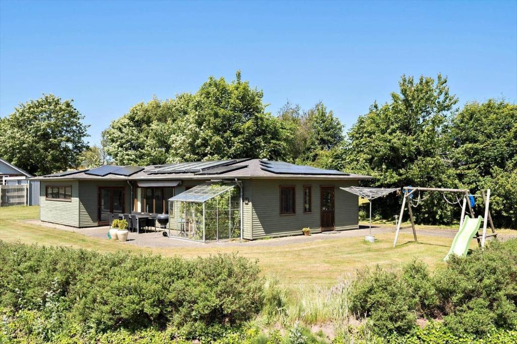 a green house with a swing and a playground at LF11597-Struer-Plantagevej-97 in Struer