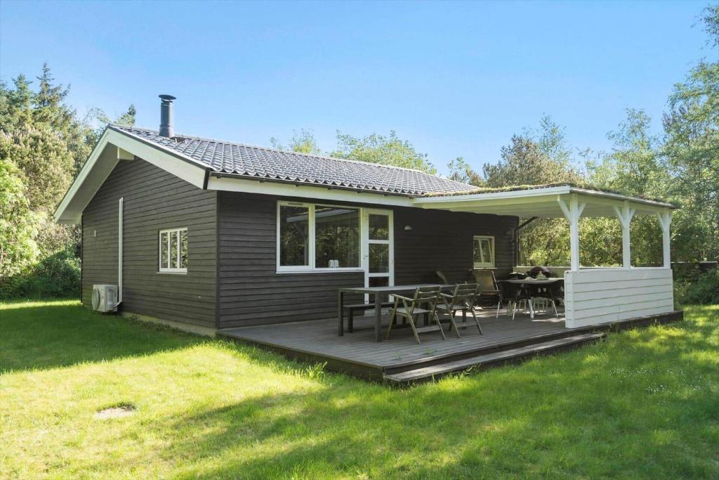 een huis met een terras met een tafel en stoelen bij LF10318-Hurup-Thy-Sortmejsevej-2 in Sønder Ydby
