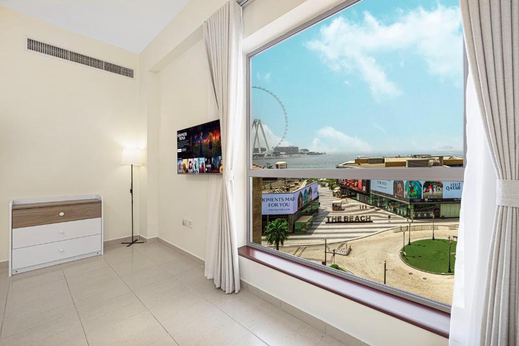 Una habitación con una gran ventana con vista a una ciudad. en Luxury Residence in the Heart of JBR, en Sabkhah