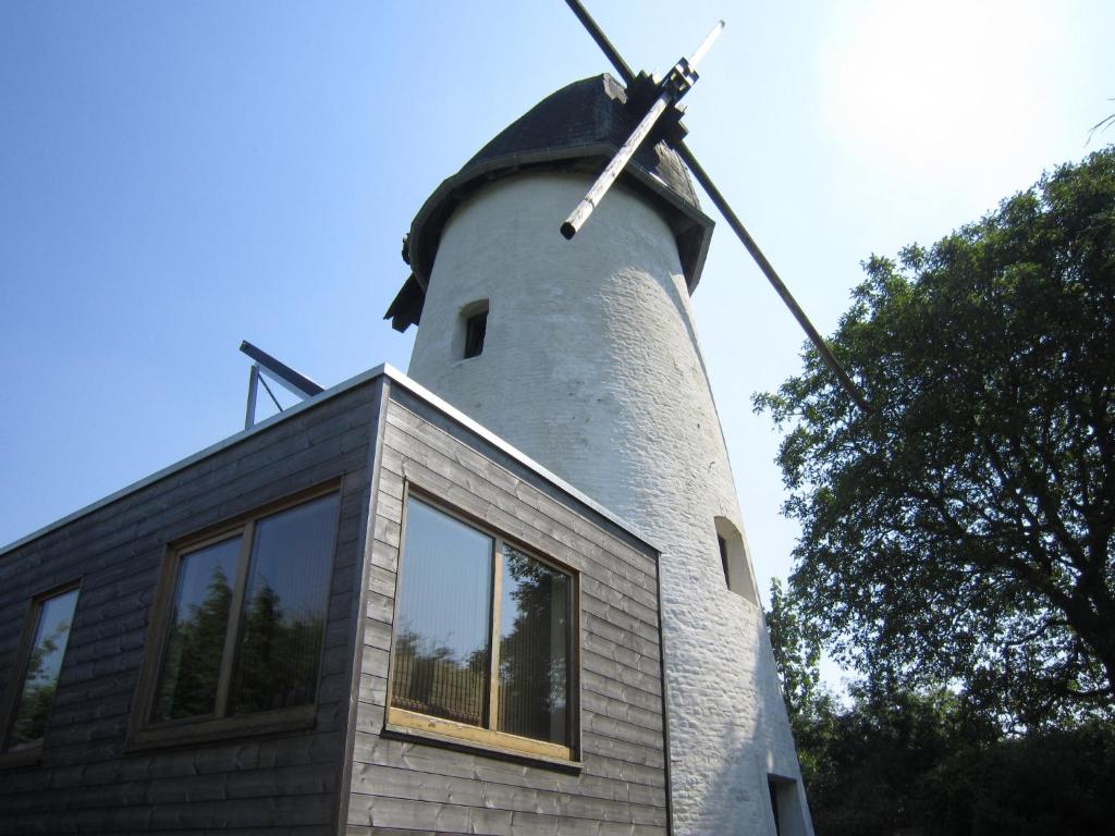 a building with a windmill on top of it at Windmill in Horebeke with Panoramic Views in Sint-Kornelis-Horebeke