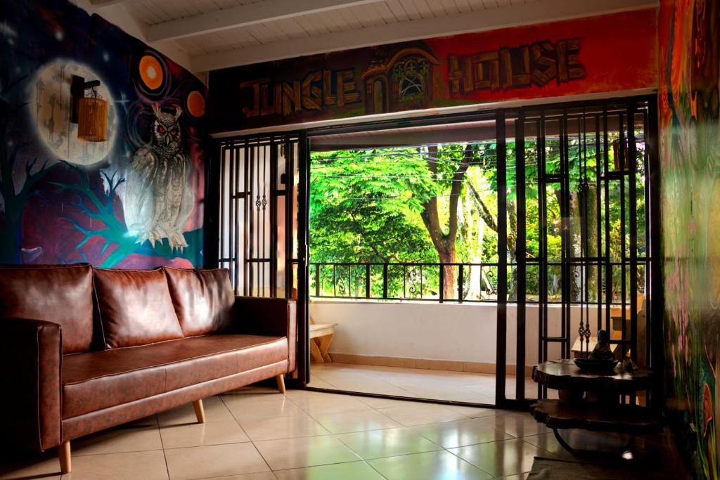 a living room with a couch and a large window at Jungle House Medellin in Medellín