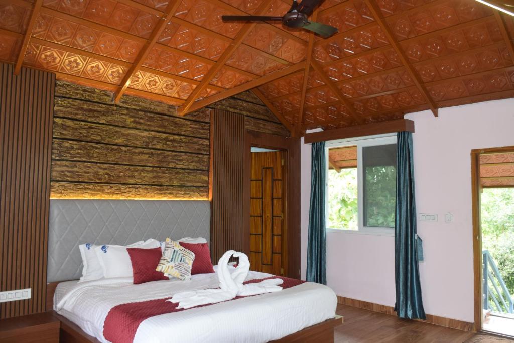 a bedroom with a bed with a ceiling at Sunrise Retreat - Kabini in Hampāpura