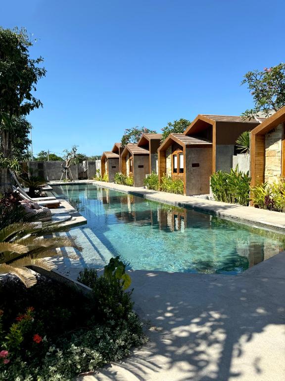 una gran piscina en un complejo con casas en Batatu Resort - Adults Only, en Kuta Lombok
