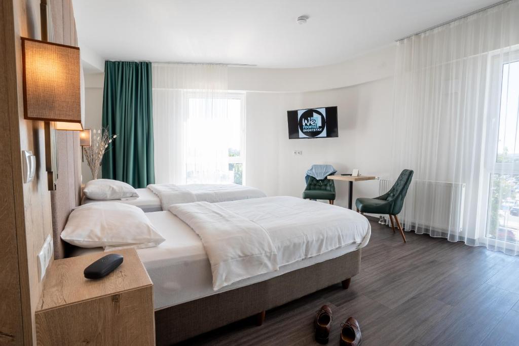 a hotel room with a bed and a desk and a room at We rooms Shortstay in Karben