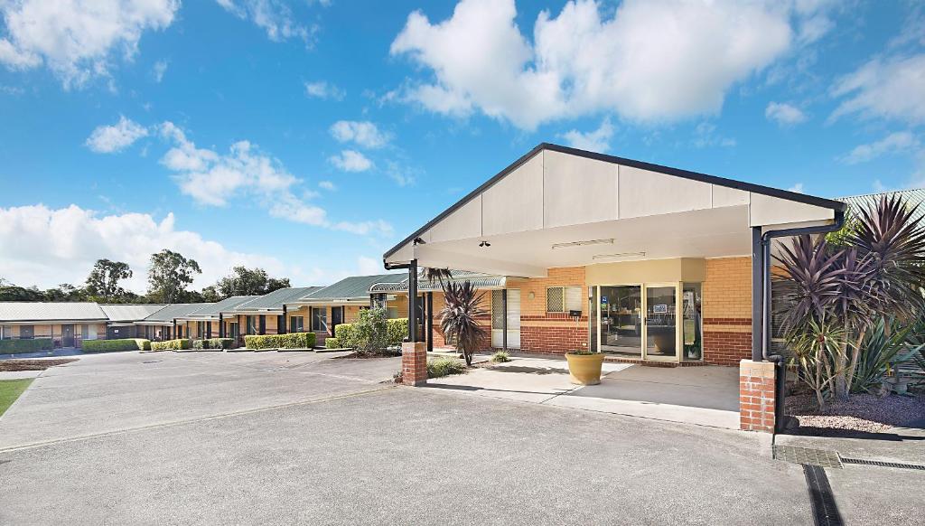 an empty parking lot in front of a building at Catalina Motel Lake Macquarie in Toronto