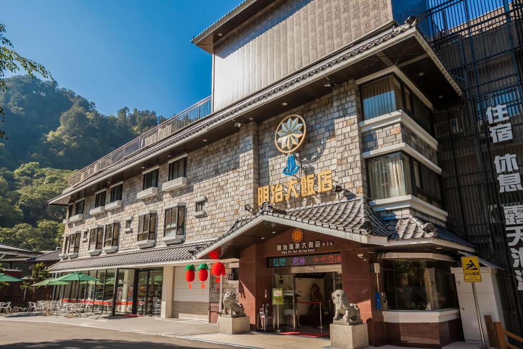 un edificio con un cartel en la parte delantera en Ming Zhi Hot Spring Hotel Building A en Heping