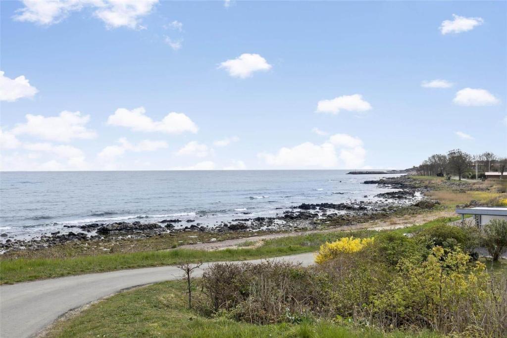 a road next to the ocean on a sunny day at 6784-Allinge-Nordre-Strandvej-127 in Allinge
