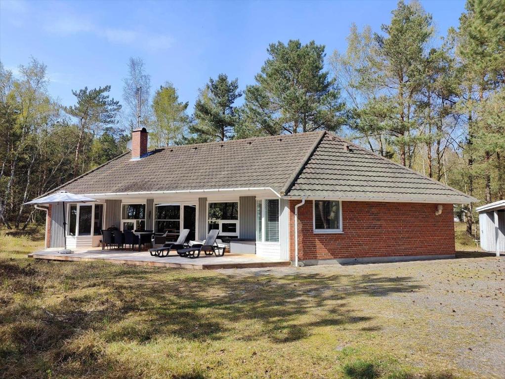 ein kleines Backsteinhaus mit einer Terrasse im Hof in der Unterkunft 1584 Aakirkeby - Poseregårdsvejen 16 in Vester Sømarken