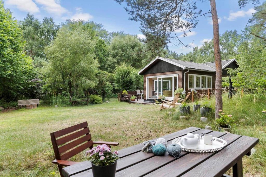 a wooden picnic table in front of a cabin at 2700-Nexo-Munkegardsskoven-3 in Neksø
