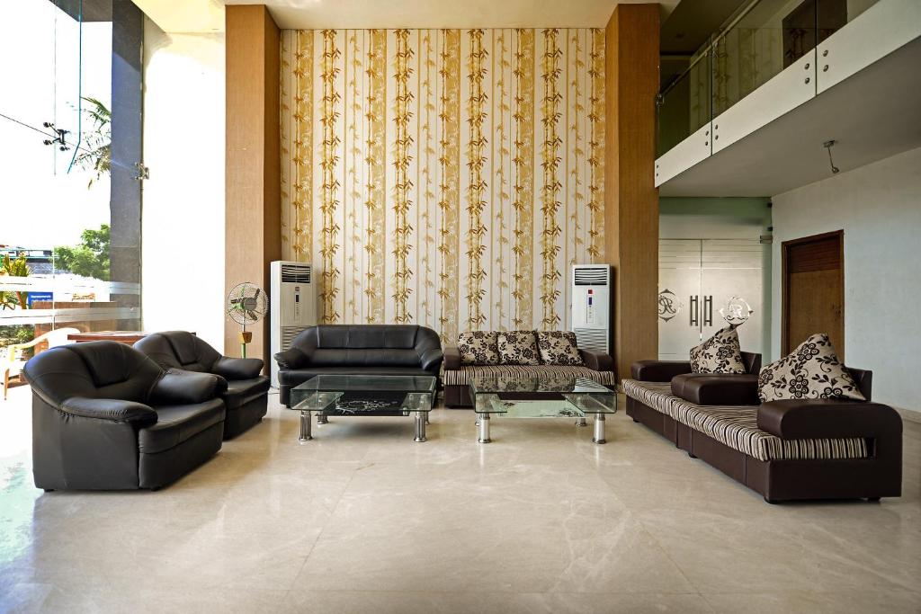 a lobby with couches and chairs and a table at Hotel O A R International in Shamshabad