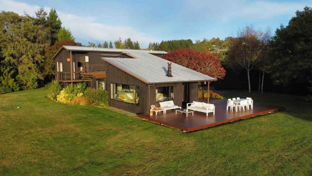 a large house with a lot of furniture in the yard at Stunning panoramic Lakeview , spa pool & privacy in Taupo