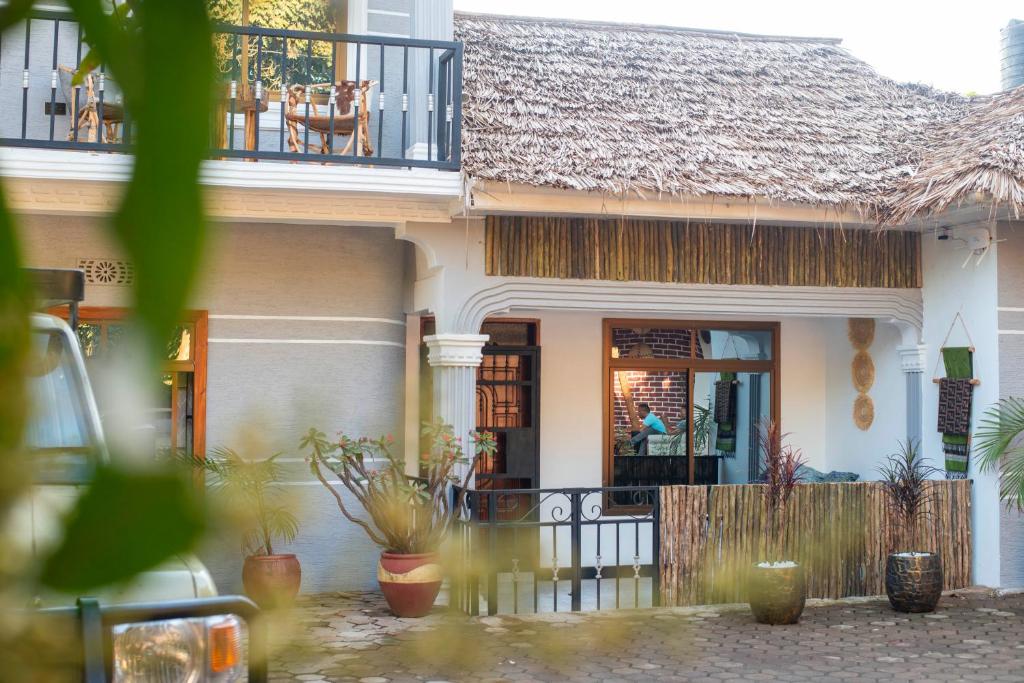 Casa con porche y balcón con plantas. en Ukarimu Hosts, en Arusha