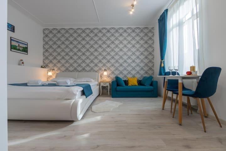 a bedroom with a bed and a blue couch at Centru Vechi Brasov in Braşov