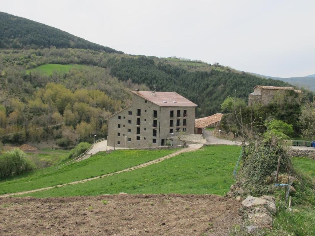 un gran edificio en una colina con un campo de césped en Apartamentos Casa Masover, en Buira