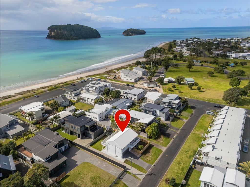 una vista aerea di una villa con un pennarello rosso di fronte alla spiaggia di Beverley Beach - Whangamata Holiday Home a Whangamata