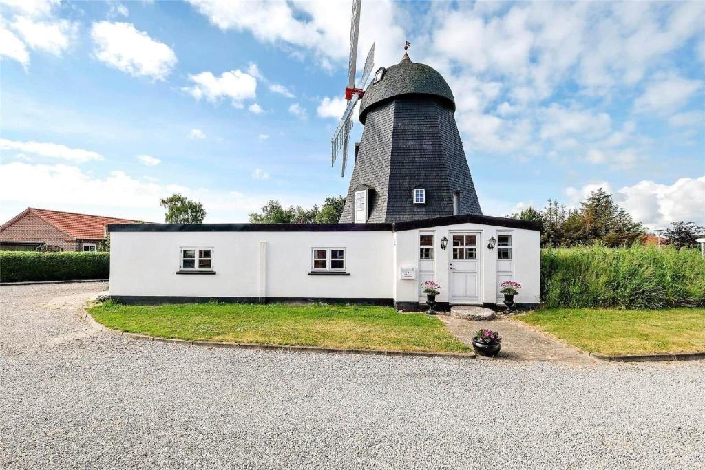 a white house with a windmill on top of it at OH300-Hadsund-Ved-Mollen-3 in Hadsund