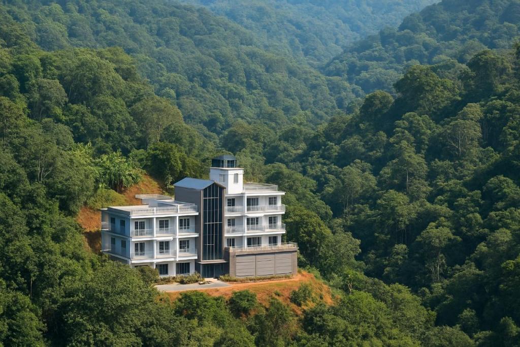 a building in the middle of a forest at Rosa Mystica Hotels & Resorts in Anachal