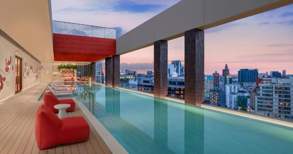 A rooftop infinity pool overlooking Bangkok’s high-rise skyline.