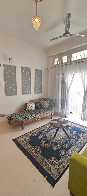 a living room with a couch and a rug at La Paloma in Dispur