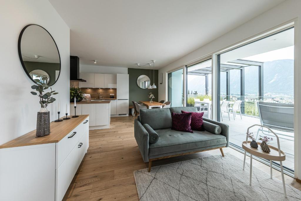 a kitchen and living room with a couch and a mirror at Panorama Apartment in Nalles